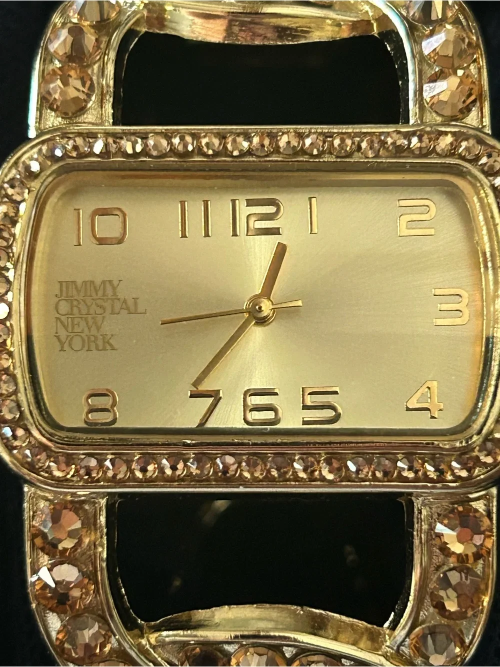 Jimmy Crystal elegant gold tone cuff watch with sparkling crystal accents.